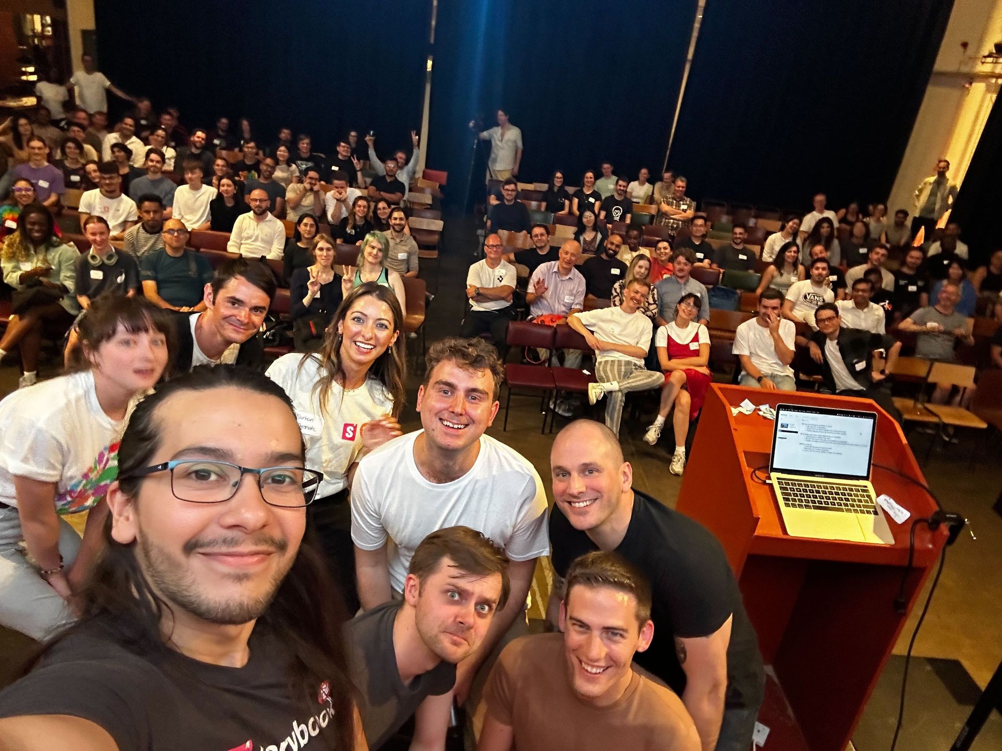 A selfie at our London event – a crowd of people looking happy and gesturing to the camera!